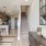 Elegant entryway at Camber Ranch featuring high ceilings, large double doors, a stylish chandelier, and stairs beside the kitchen area