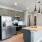 Modern kitchen with a dark color scheme, featuring sleek cabinetry, a contrasting countertop, and stylish appliances