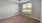 Empty bedroom at Camber Ranch with ceiling fans, neutral walls, carpeted floor, and a large window allowing natural light